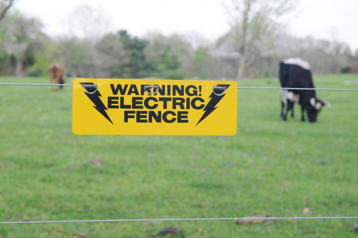 A yellow sign that reads "warning! electric fence"
