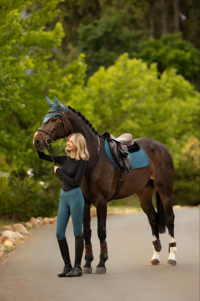 Rider and dark horse matching in the vibrant LeMieux SS26 Jungle green collection, featuring riding breeches, a saddle pad, and a fly hood.